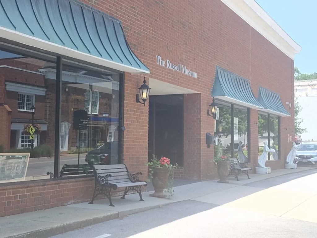The Russell Museum exterior, brick building with awnings and benches.