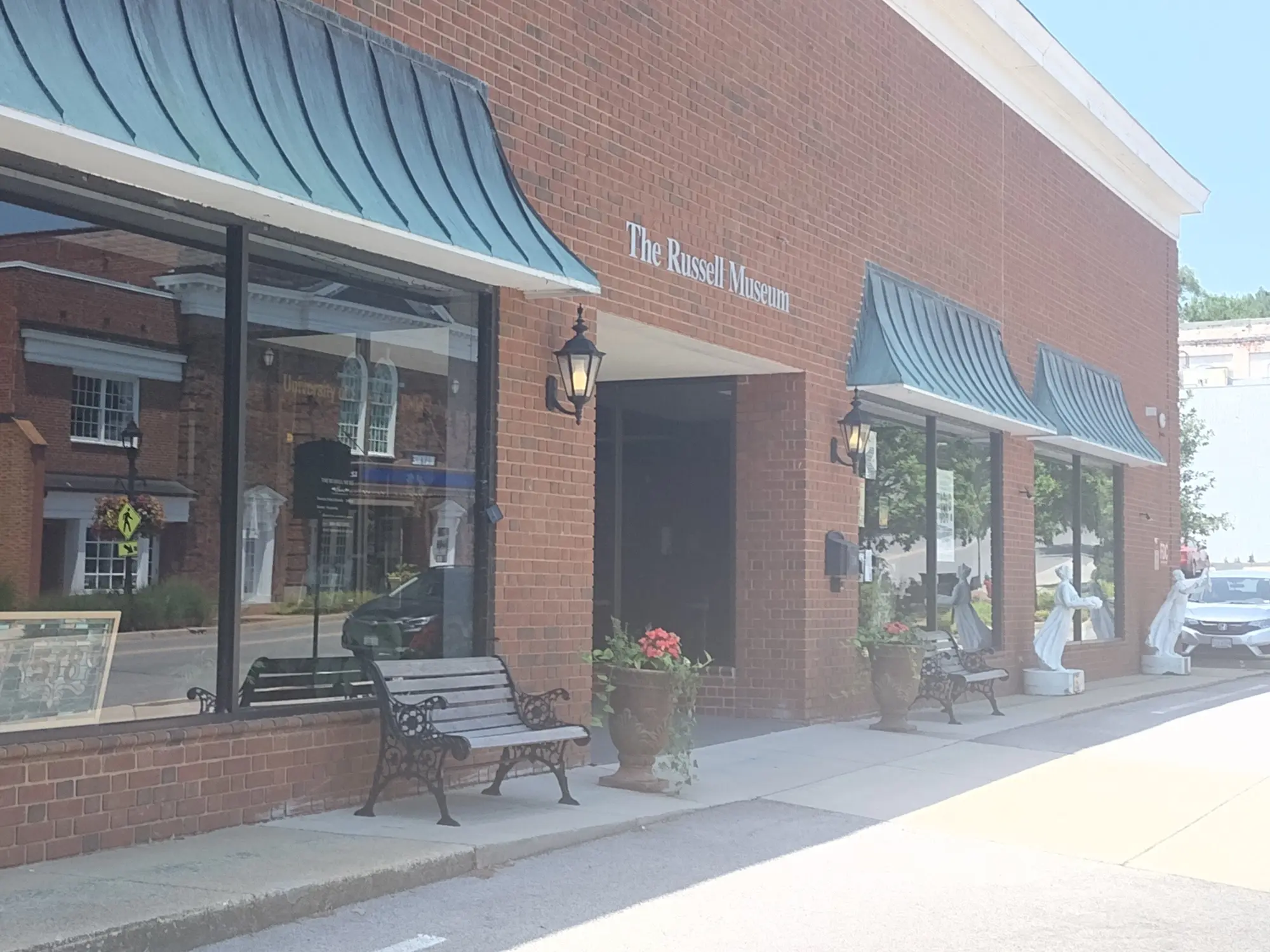 The Russell Museum exterior, brick building with awnings and benches.