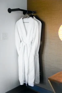 White bathrobe hanging on a wall hook
