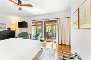 Bedroom with king bed, patio doors, and hardwood floors.