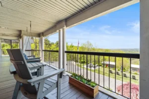 A porch featuring several chairs and a railing.