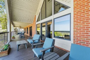 outdoor seating area with blue chairs and large windows.