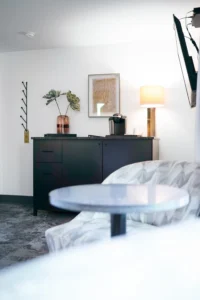 seating area, a stylish cabinet, a lamp, and decorative elements like plants and art.