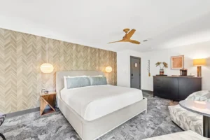 Bedroom with queen bed with ceiling fan.