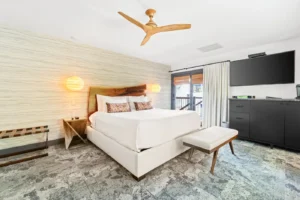Woodland room with king bed, wood accents, and fan.