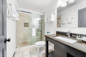 Bathroom with shower, sink, mirror, and marble counters.