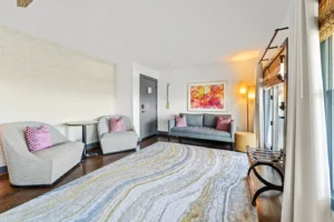 Living room with gray sofa, armchairs, and abstract art