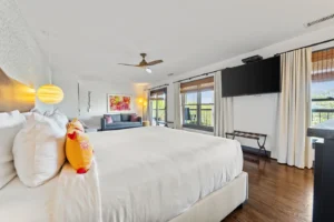 A Bedroom featuring a large bed and gray sofa.