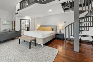 Deep Woods Cottage bedroom with bed, studio couch, and staircase to loft.