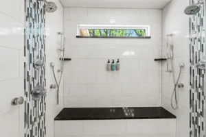 A modern, tiled walk-in shower with a built-in bench.