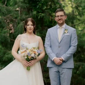 A bride in a flowing white gown holds a bouquet.